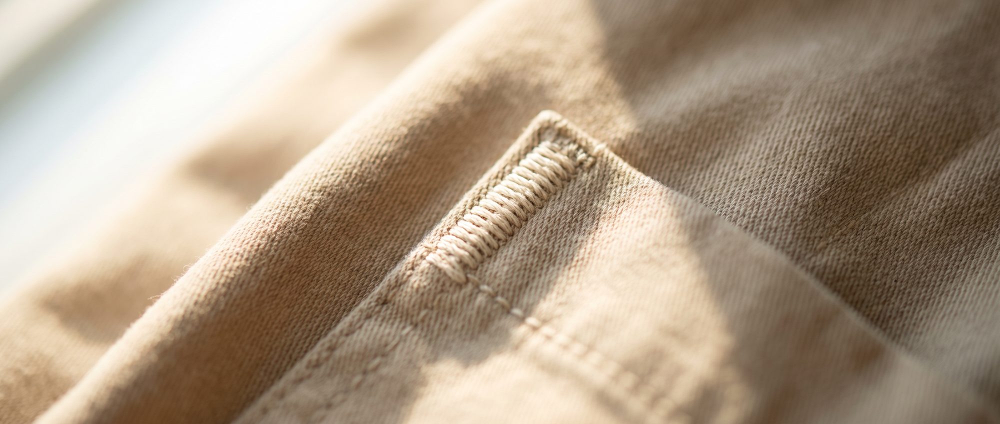 Macro detail of a ribbed edge meeting the placket on a knit garment