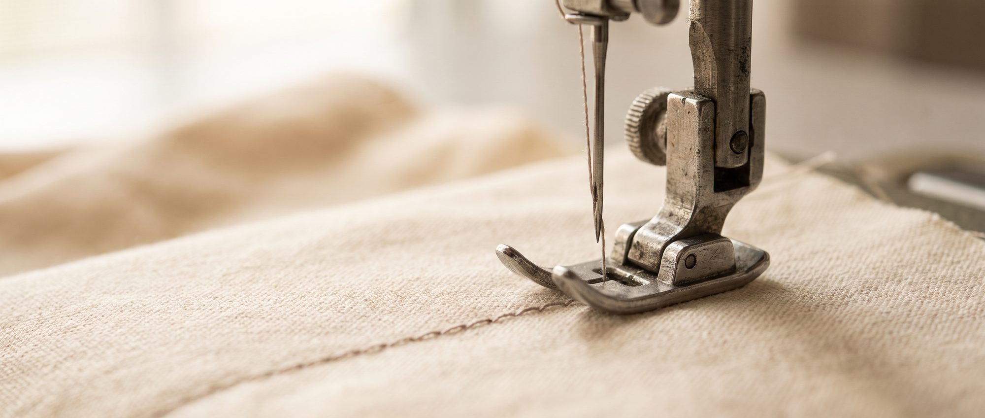 Macro detail of a seam being closed under a single-needle machine foot