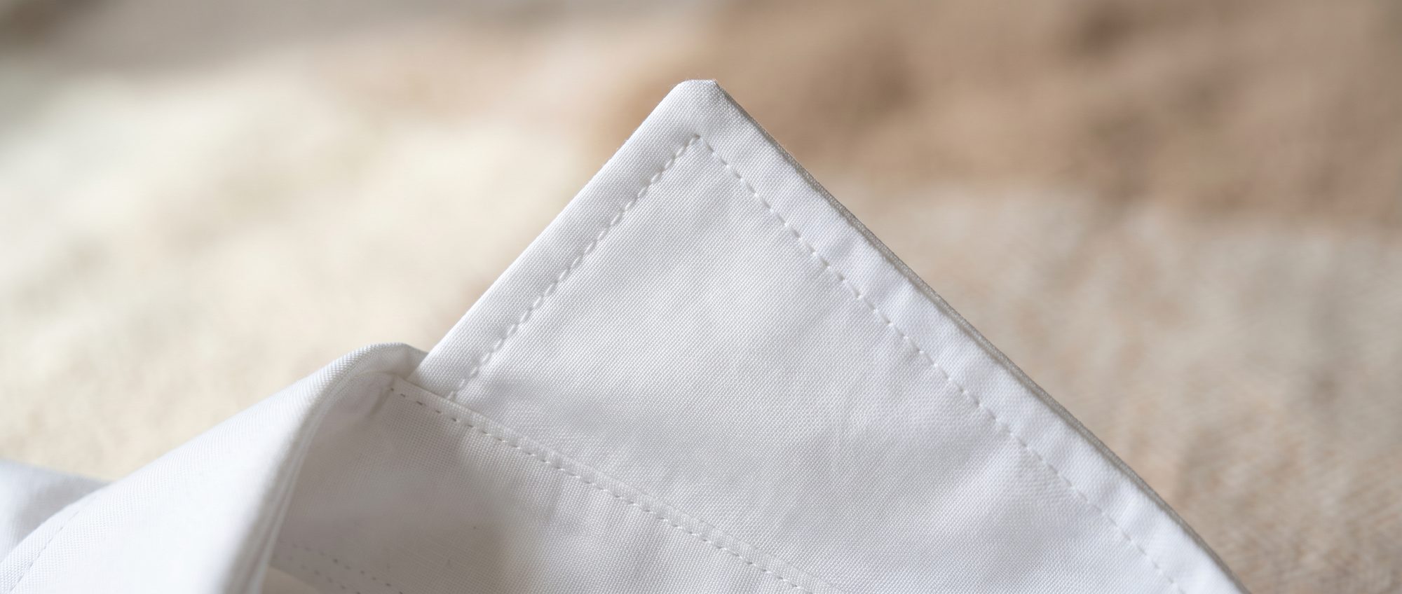 Macro detail of a crisp pressed fold on a finished white shirt