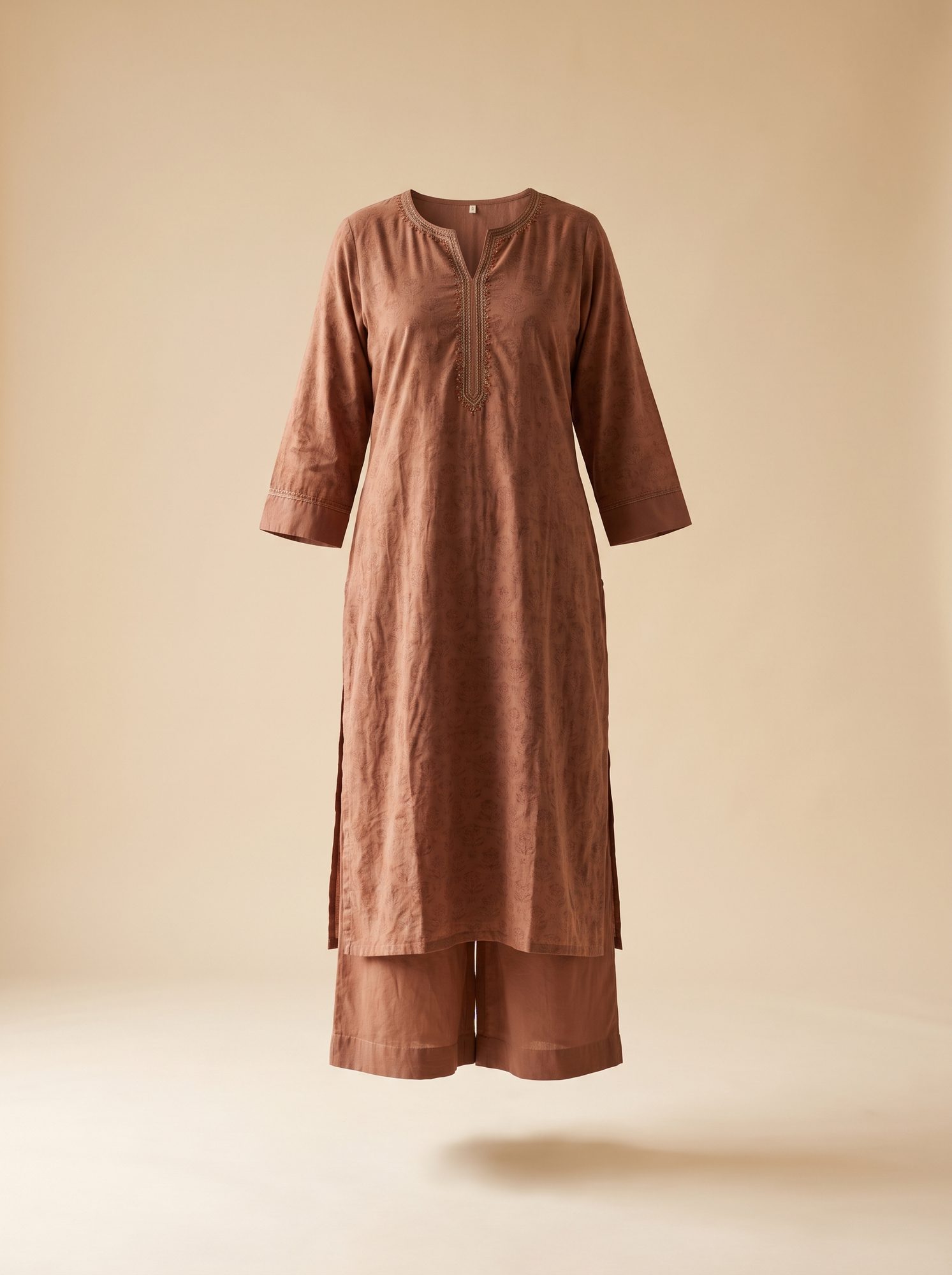 Rust-coloured embroidered kurta with matching trouser, photographed full length